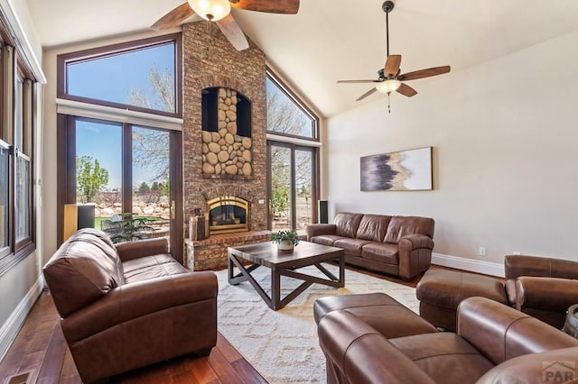 living room featuring baseboards, a ceiling fan, and wood-type flooring