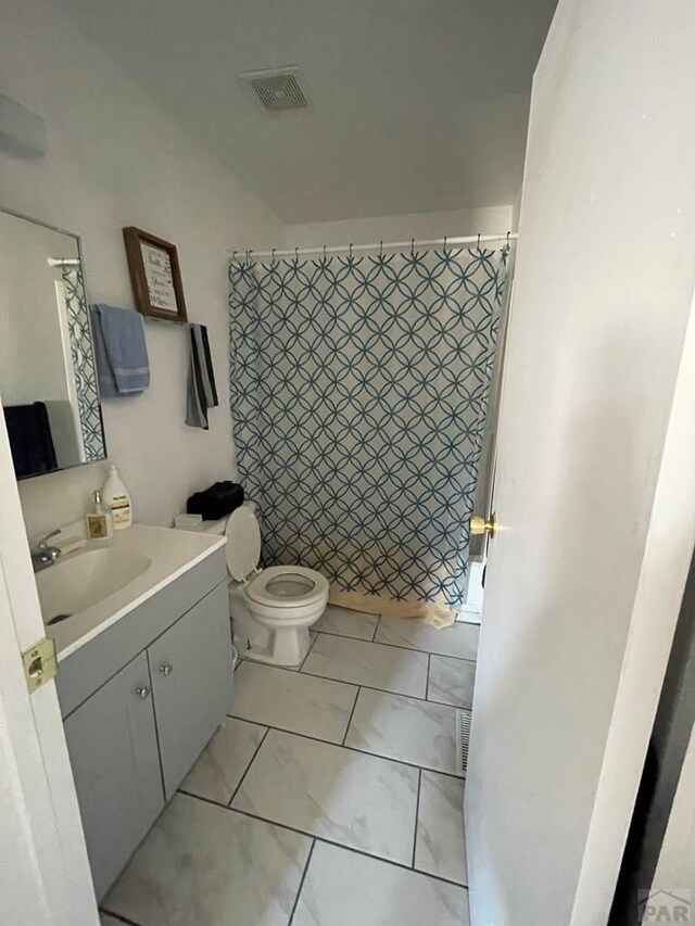 bathroom featuring a shower with curtain, visible vents, vanity, and toilet