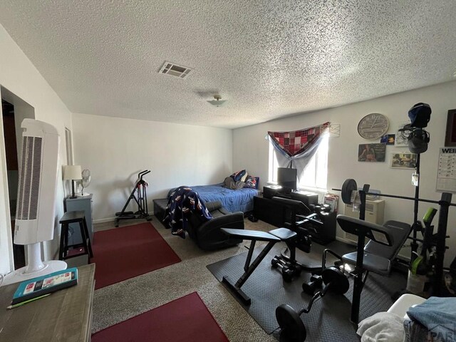 carpeted bedroom featuring a textured ceiling and visible vents