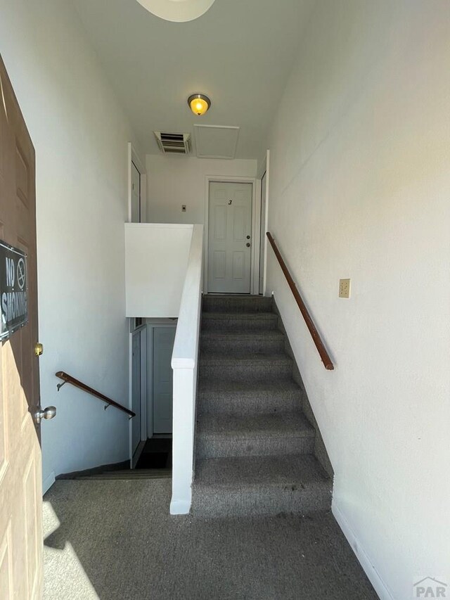 stairway with carpet flooring, visible vents, and baseboards