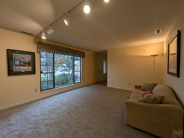 living room featuring baseboards, visible vents, a textured ceiling, and carpet flooring