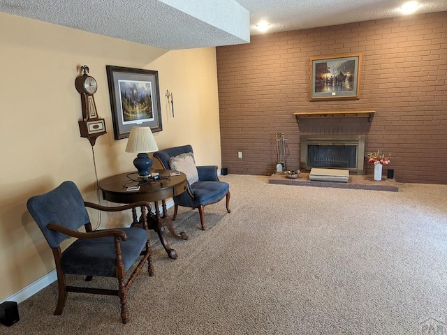 sitting room with carpet, a fireplace, a textured ceiling, and brick wall