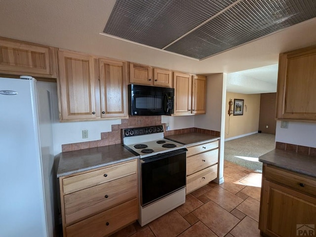 kitchen with dark countertops, electric range, light brown cabinetry, freestanding refrigerator, and black microwave