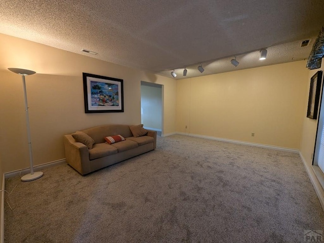 unfurnished living room with visible vents, carpet flooring, a textured ceiling, and baseboards