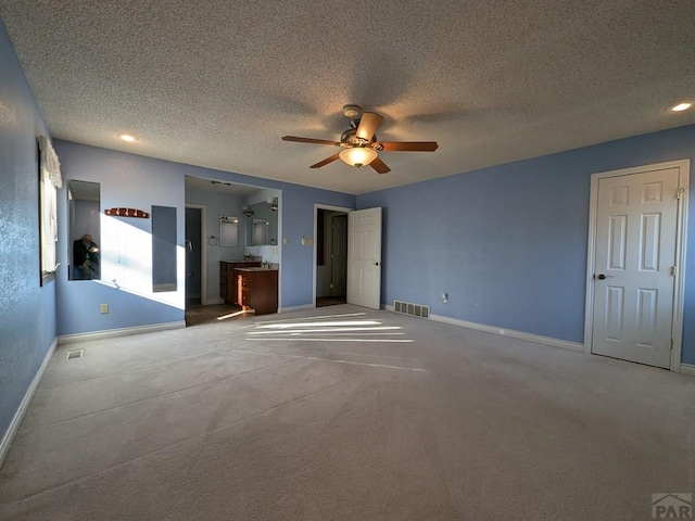 unfurnished bedroom with a textured ceiling, visible vents, and baseboards