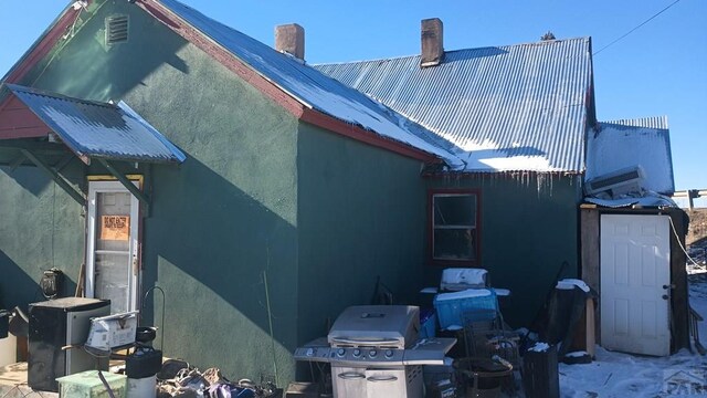 view of side of property featuring metal roof and stucco siding