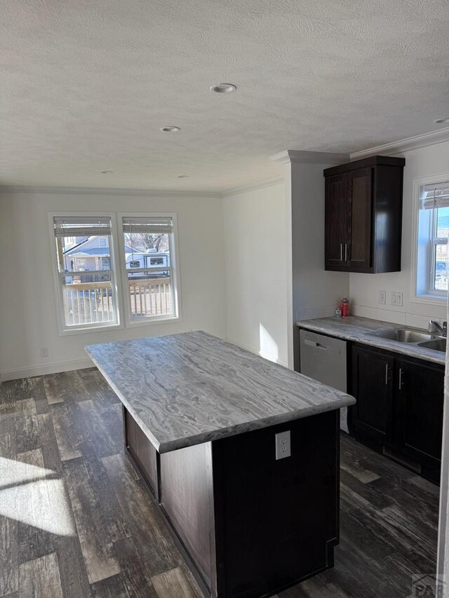 kitchen featuring crown molding, a kitchen island, dark wood finished floors, and a sink