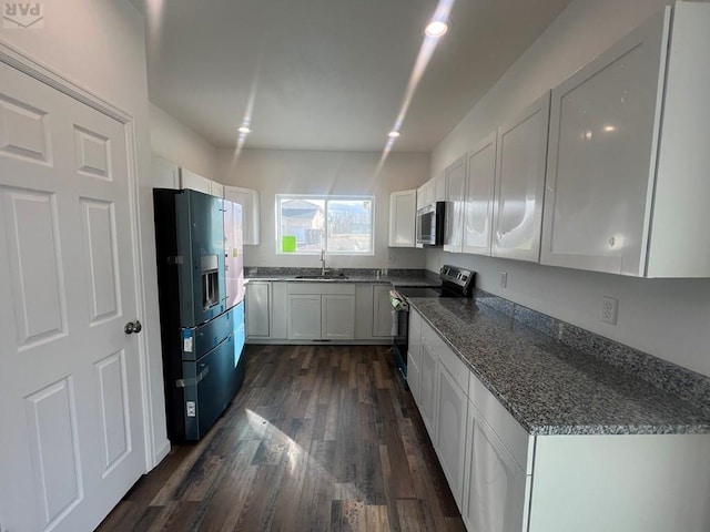 kitchen featuring a sink, dark stone countertops, dark wood-style floors, white cabinetry, and stainless steel appliances