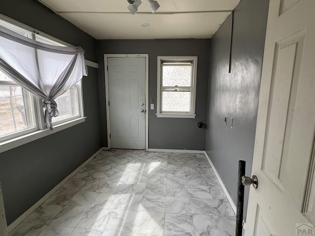 interior space featuring baseboards and marble finish floor