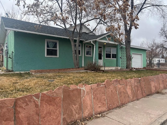 view of front of home featuring stucco siding, an attached garage, a shingled roof, and fence