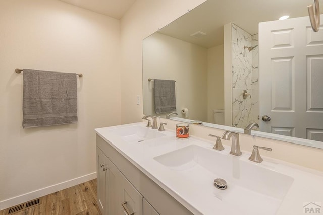 full bathroom with visible vents, a sink, toilet, and double vanity