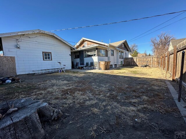 rear view of house with a fenced backyard and a patio