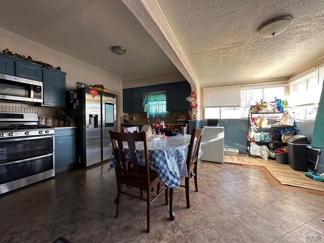 dining space with a textured ceiling and ornamental molding