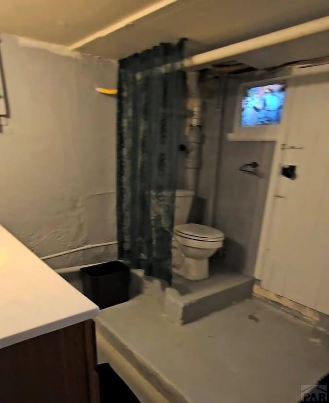 bathroom featuring toilet, vanity, and a shower with curtain