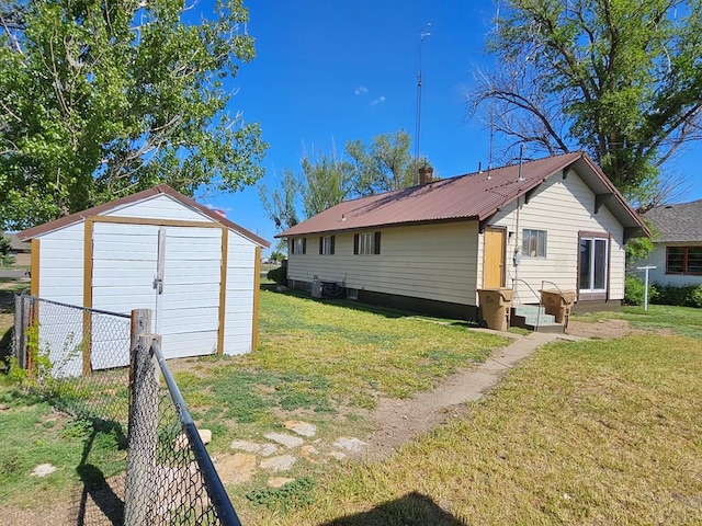 425 Randolph St, Pritchett, CO 81064 - rear view of property featuring a yard, a storage shed, fence, and an outbuilding