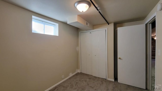 interior space featuring light carpet, baseboards, visible vents, and a closet