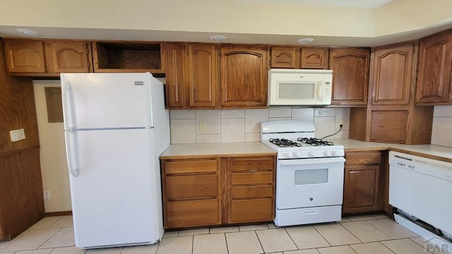 kitchen with white appliances, brown cabinetry, light countertops, open shelves, and backsplash