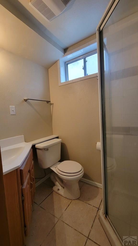 full bathroom with visible vents, toilet, a shower stall, vanity, and tile patterned flooring