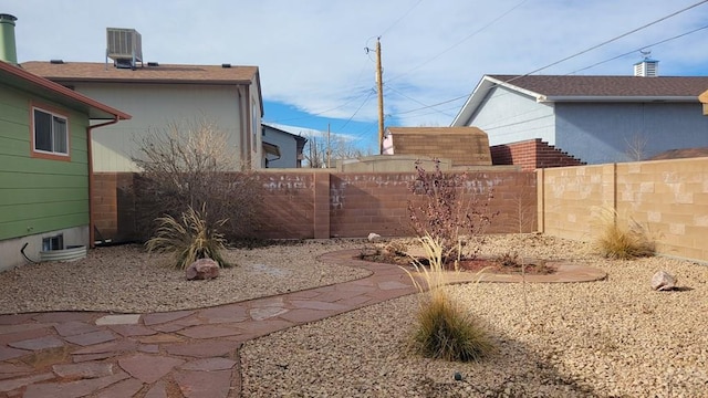 view of yard with a fenced backyard and central air condition unit