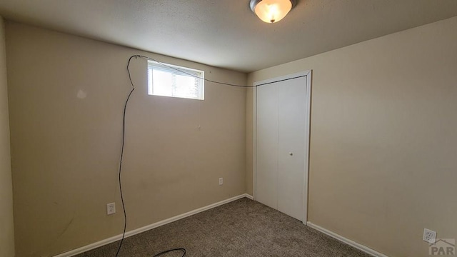 below grade area featuring carpet floors and baseboards