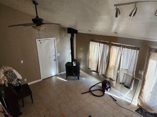 7787 State Highway 78, Beulah, CO 81023 - entryway featuring ceiling fan, a wood stove, a textured ceiling, baseboards, and tile patterned floors