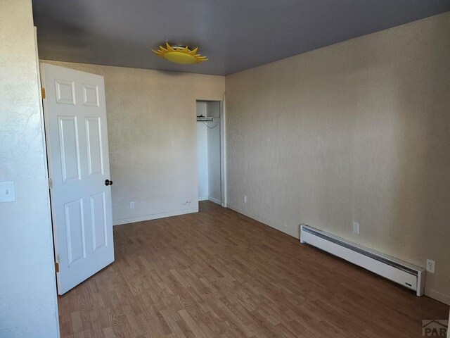 7787 State Highway 78, Beulah, CO 81023 - unfurnished room featuring a baseboard radiator, wood finished floors, and baseboards