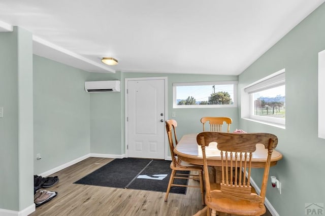 181 6th St, Penrose, CO 81240 - dining space with a wall mounted AC, wood finished floors, and baseboards