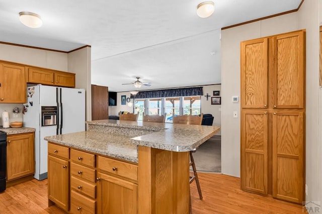 181 6th St, Penrose, CO 81240 - kitchen featuring white refrigerator with ice dispenser, a breakfast bar area, light wood-style flooring, a kitchen island, and crown molding