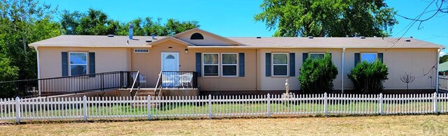 view of front of home featuring a fenced front yard, a front yard, and stucco siding