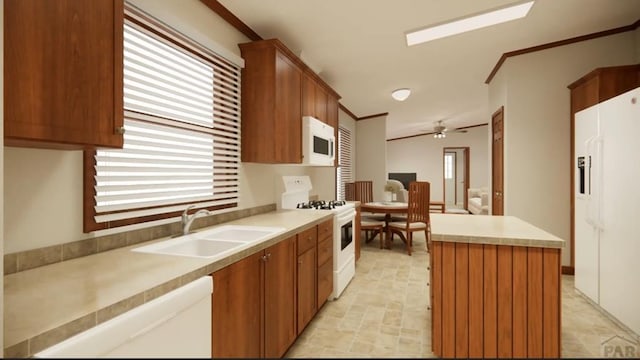 kitchen featuring light countertops, ornamental molding, a sink, a kitchen island, and white appliances