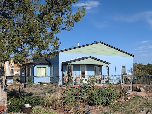 view of front of property with a fenced front yard, a gate, and stucco siding