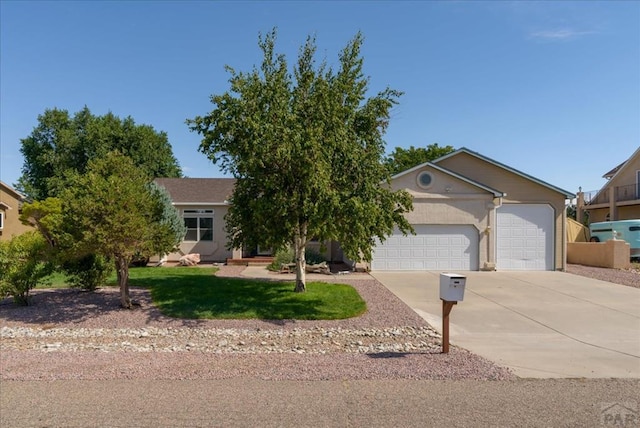 view of front of home with concrete driveway, a front yard, an attached garage, and stucco siding