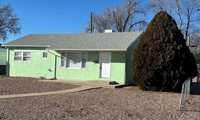 view of front of property with a shingled roof, a chimney, and stucco siding