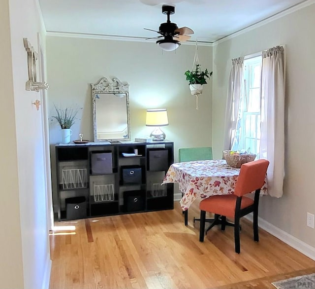 dining area featuring baseboards, wood finished floors, and crown molding