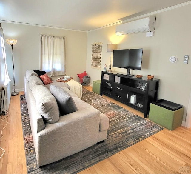 living area featuring baseboards, crown molding, a wall unit AC, and wood finished floors