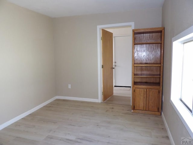 unfurnished room with light wood-style floors and baseboards