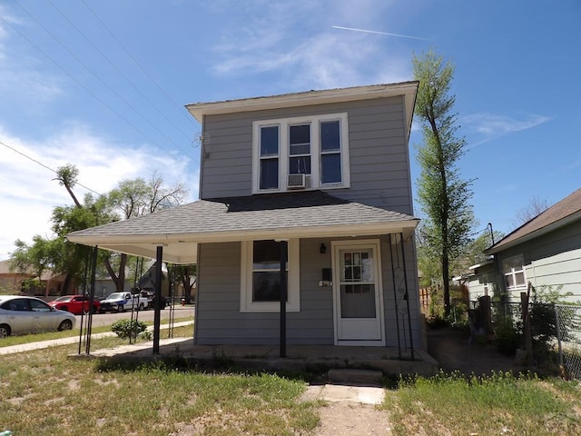 view of front of house with a porch, roof with shingles, and fence