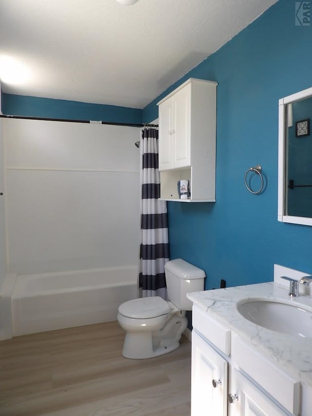 full bathroom featuring toilet, wood finished floors, vanity, and shower / tub combo with curtain