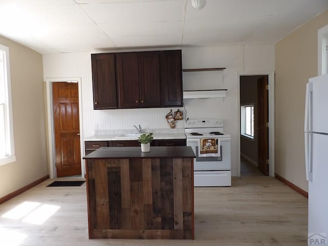 kitchen featuring white appliances, under cabinet range hood, open shelves, and light wood-type flooring