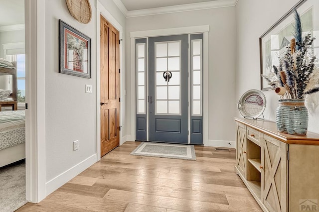 entryway featuring baseboards, light wood-style floors, and ornamental molding