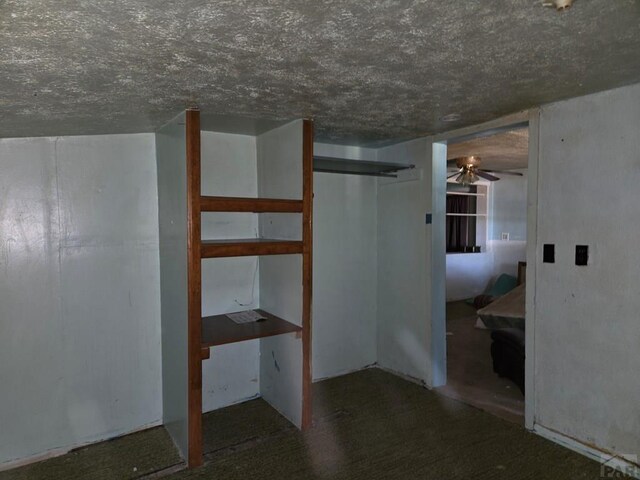 interior space with a textured ceiling and a ceiling fan