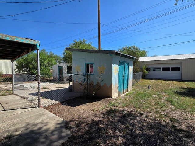 view of outdoor structure featuring fence and an outbuilding