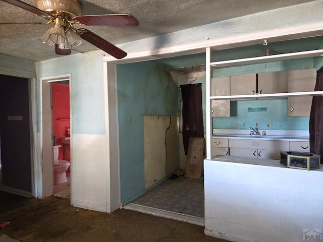 kitchen with a ceiling fan and a textured ceiling