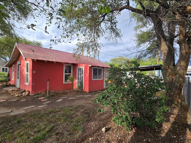 back of house featuring fence and stucco siding