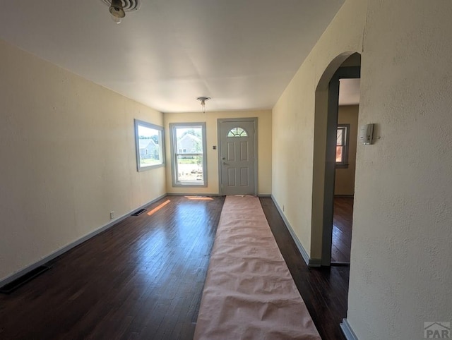 422 Grove Ave, Las Animas, CO 81054 - foyer entrance featuring dark wood-type flooring, arched walkways, and a textured wall