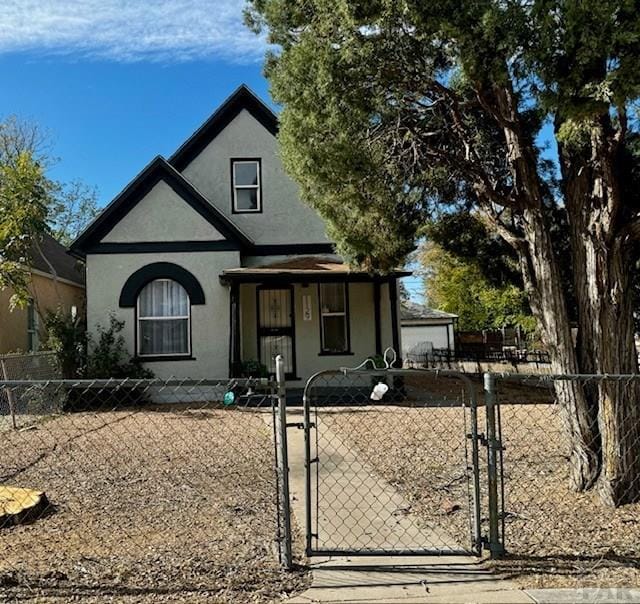 view of front of home featuring a fenced front yard, a gate, and stucco siding