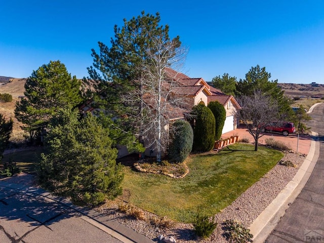 view of front of property featuring a front yard and a tile roof