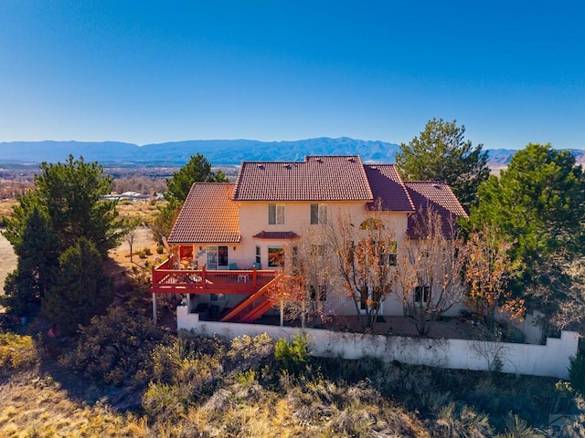 back of house with stairway, a tile roof, and a deck with mountain view