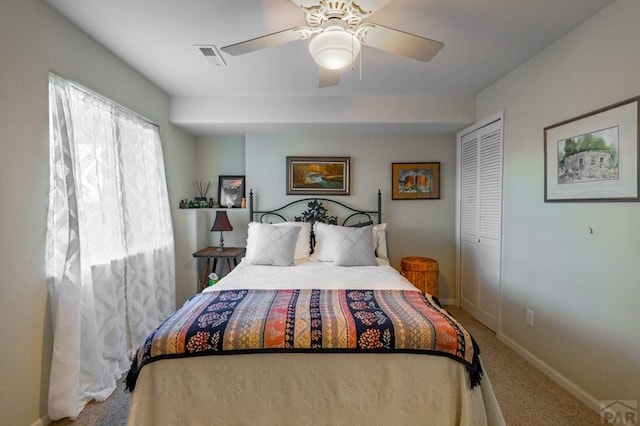 carpeted bedroom with a ceiling fan, a closet, visible vents, and baseboards