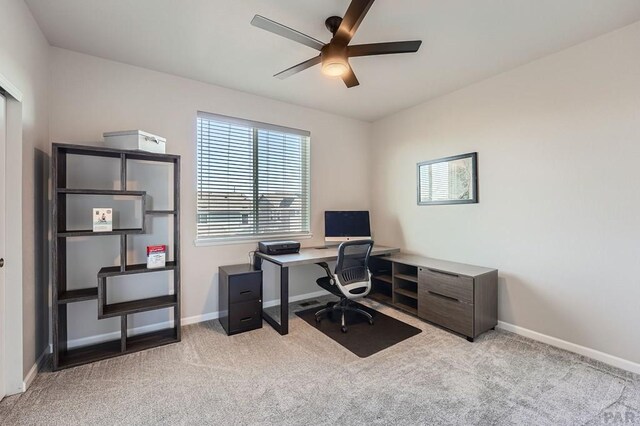 office area with light colored carpet, ceiling fan, and baseboards